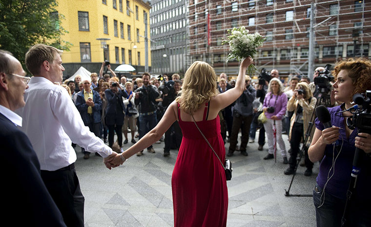 Norway attacks aftermath: A newly wed couple walks out into the media scrum