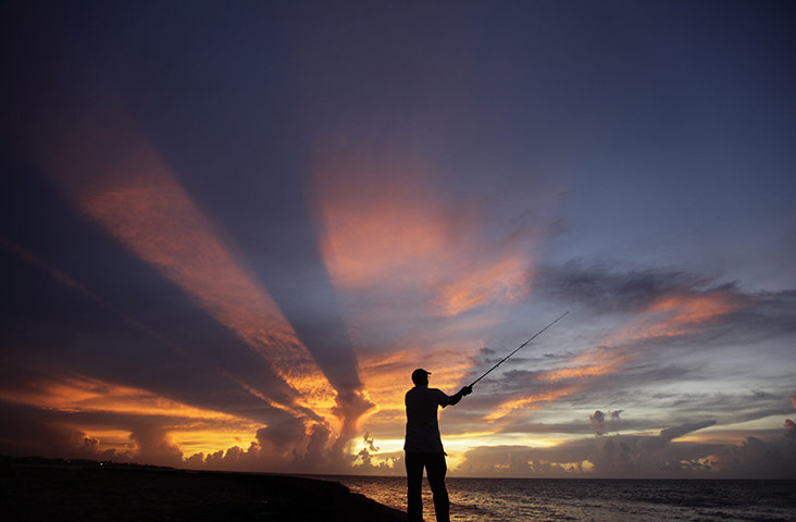 24 hours in pictures: A fisherman casts his line as the sun sets on the outskirts of Havana