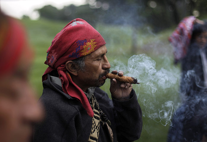 FTA: Jorge Dan Lopez: A man smokes tobacco as an offering during the Day of the Birds ceremony