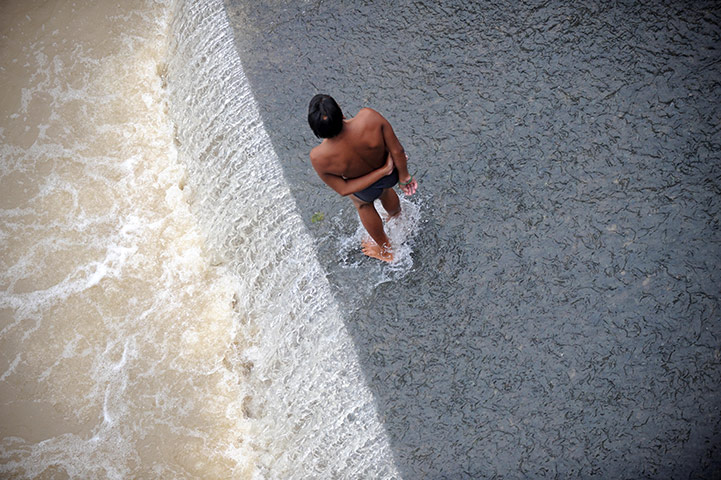 24 hours in pictures: A boy bathes in a creek connected to San Mateo River in Manila