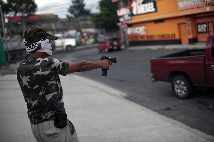 FTA: Jorge Dan Lopez: An armed villager points his gun at a car entering the village of Castanas