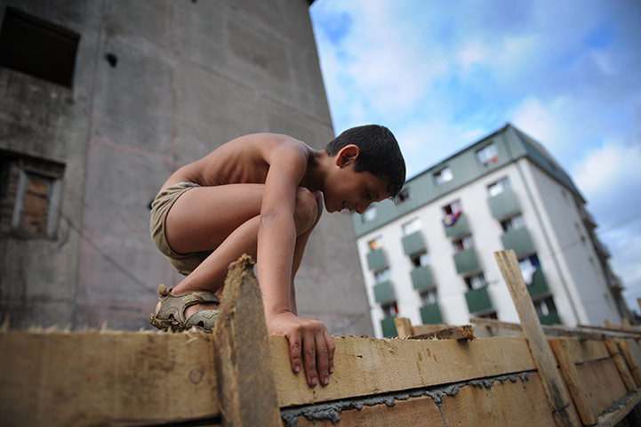 24 hours in pictures: A Roma child climbs on a concrete wall 