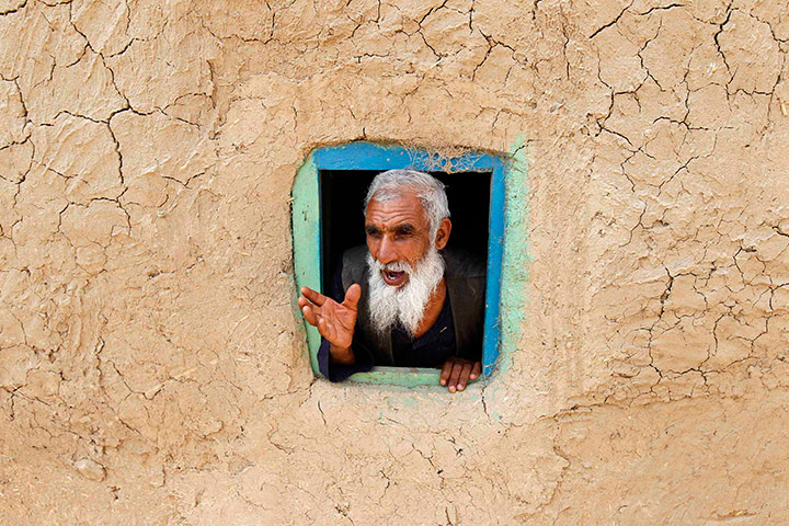24 hours in pictures: Afghan man talks from small window in Kabul