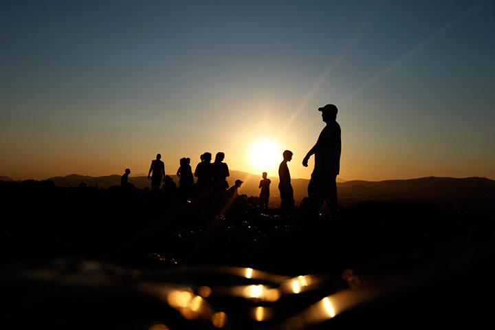24 hours in pictures: Tourists are silhouetted against on the Areopagus Hill, Athens