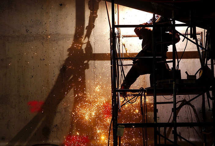 24 hours in pictures: A welder at work on the National September 11 Memorial and Museum