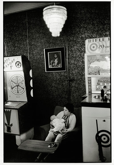 Blackpool: Young woman with a baby seated in amusement arcade