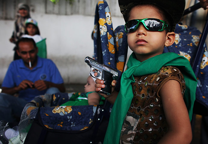 24 hours in pictures:  Libyan boy poses with a toy gun during a demonstration against NATO