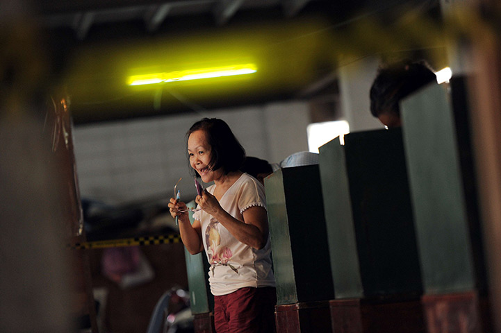 Thailand elections: A Thai woman smiles as she leaves a booth after voting