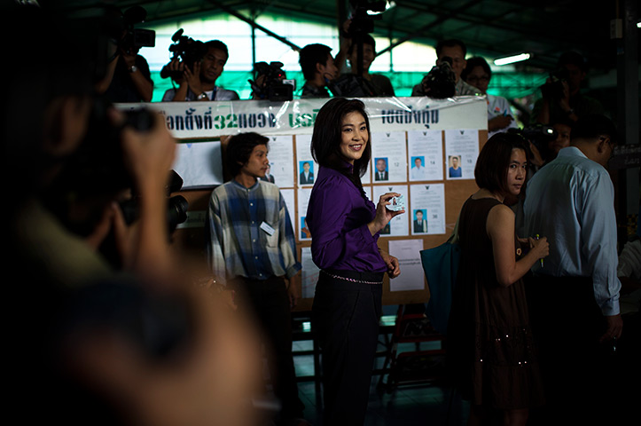 Thailand elections: Yingluck Shinawatra shows her ID card during voting at polling station