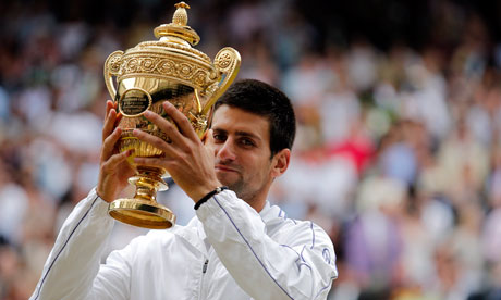 Novak Djokovic hoists the championship trophy following his victory at Wimbledon Championships