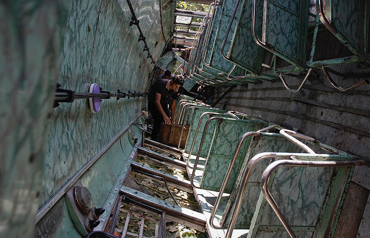 24 hours in pictures: A Kashmiri villager searches the wreckage of an overturned bus