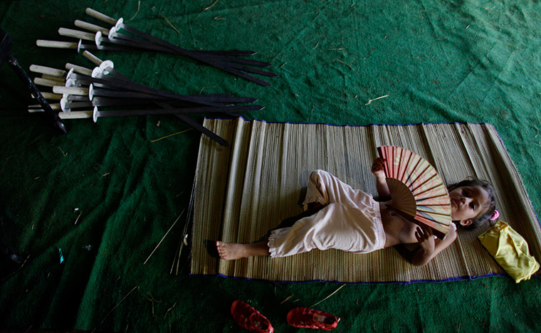 24 hours in pictures: A girl lies next to swords at the 