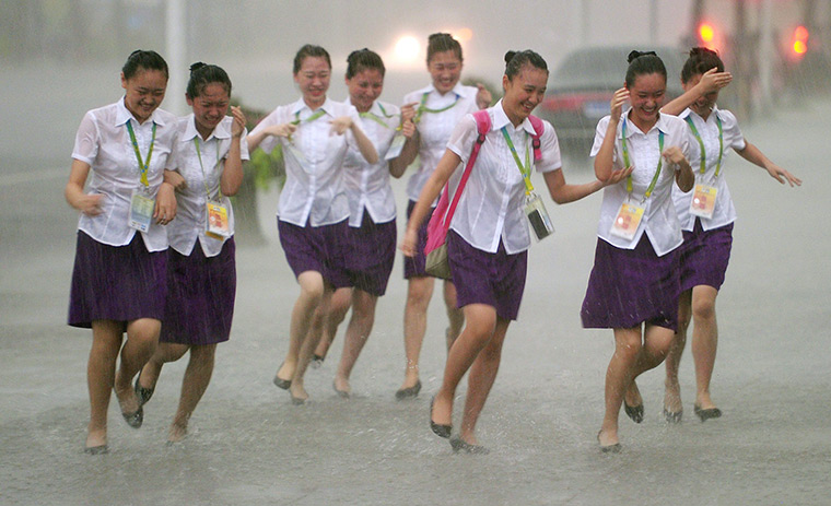 24 hours in pictures: Chinese volunteers run through rain at FINA Swimming World Championships
