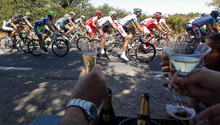Tour de France Update: Supporters hold glasses of sparkling white wine during the Tour de France