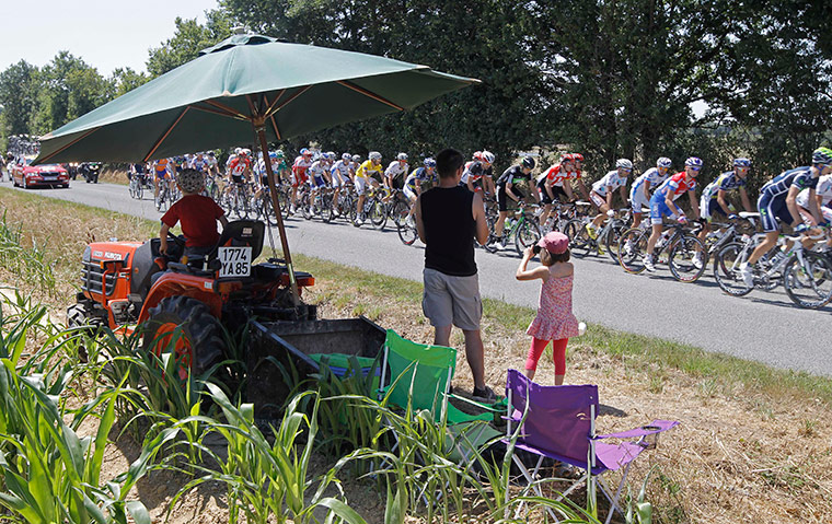 Tour de France Update: Spectators shield themselves as the pack with Thor Hushovd in yellow