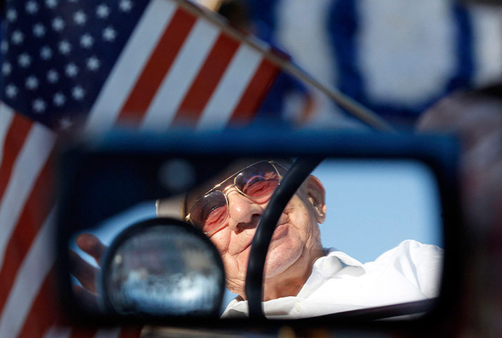 24 hours in pictures: Man waits before the start of the Independence Day Parade, Iowa