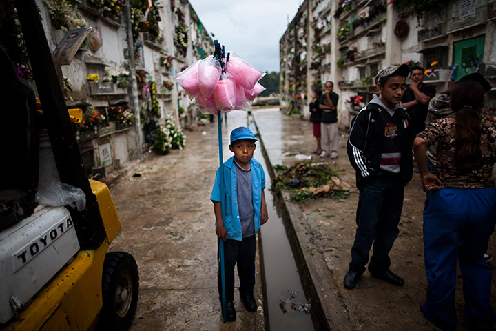 24 hours in pictures: Boy for customers to to sell cotton candy, Guatemala City