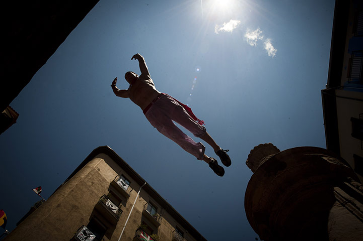 Pamplona revellers: A reveller jumps a fountain in Pamplona, Spain 