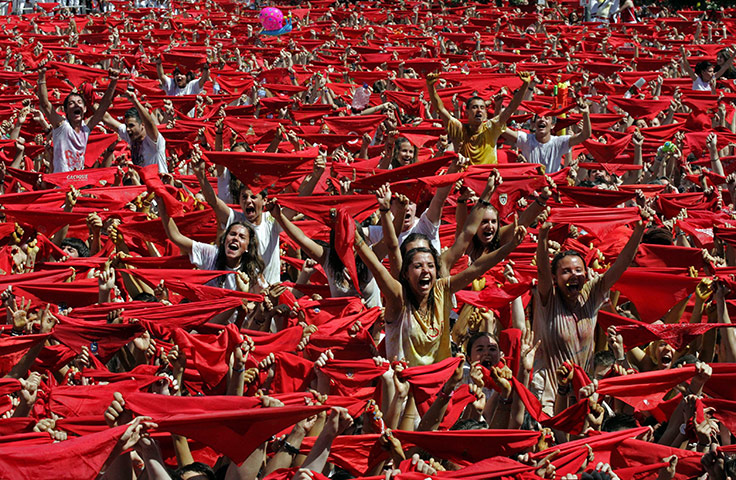 Pamplona revellers: Thousands of people wave red scarves