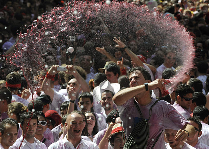Pamplona revellers: Revellers are sprayed with wine during the start of the San Fermin Festival