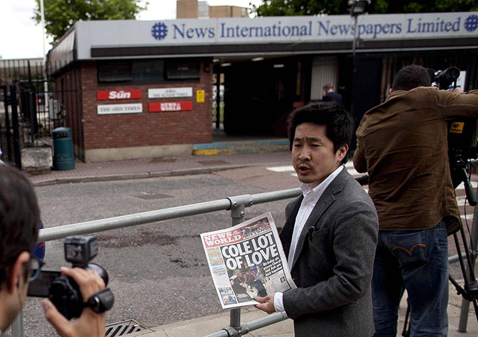 News of The World History: A Japanese journalist holds up a copy the News of the World