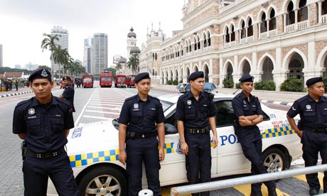 Malaysian police line up near water cannon trucks in a Kuala Lumpur street