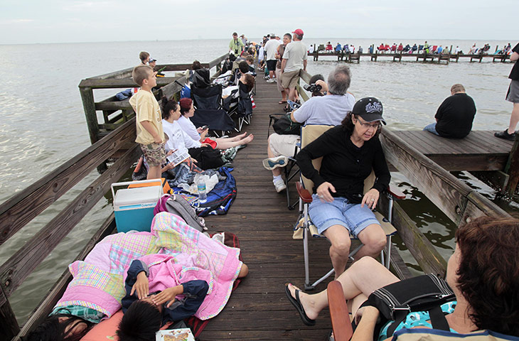 Shuttle Final Launch: Onlookers fill a waterfront dock while waiting for the space shuttle launch