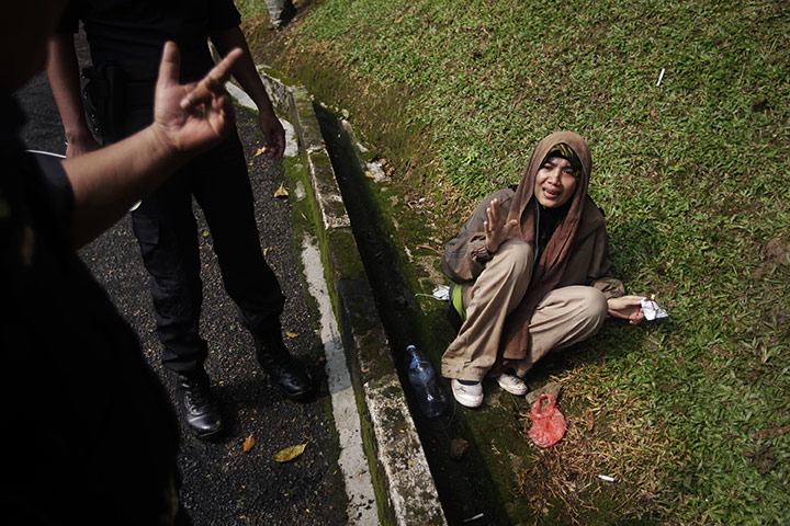 24 Hours in Pictures: A supporter of the 'Bersih' electoral reform coalition detained by police