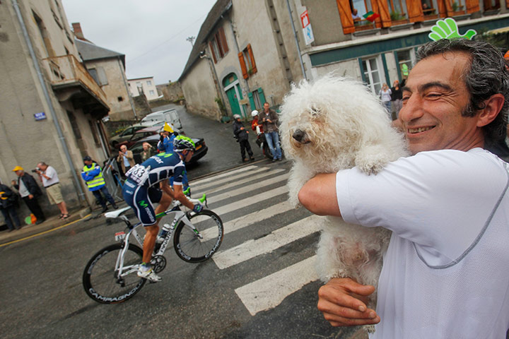 Tour De France stage 8: A fan & his dog look on as Rui Alberto Costa of Portugal passes