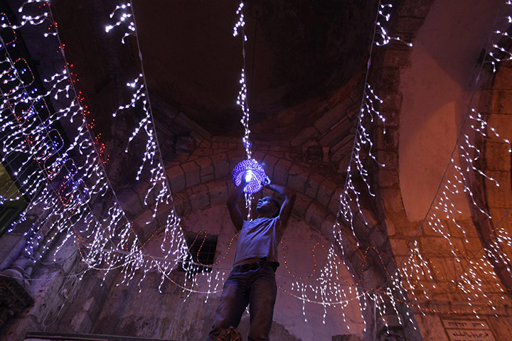 24 hours: Jerusalem: A Palestinian man hangs decorations for Ramadan