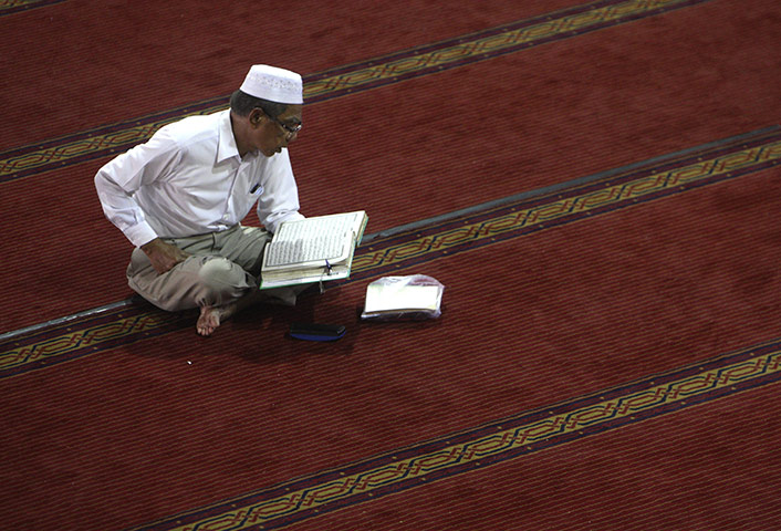 Ramadan: A man reads the Quran t Istiqlal Mosque in Jakarta, Indonesia 
