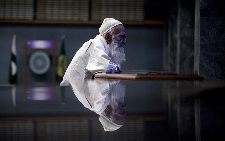 24 hours in pictures: An elderly man monitors share prices at the Karachi Stock Exchange