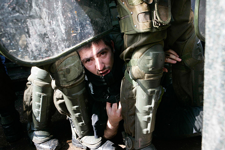 24 hours in pictures: A demonstrator is seen after being arrested during a students' rally, Chile