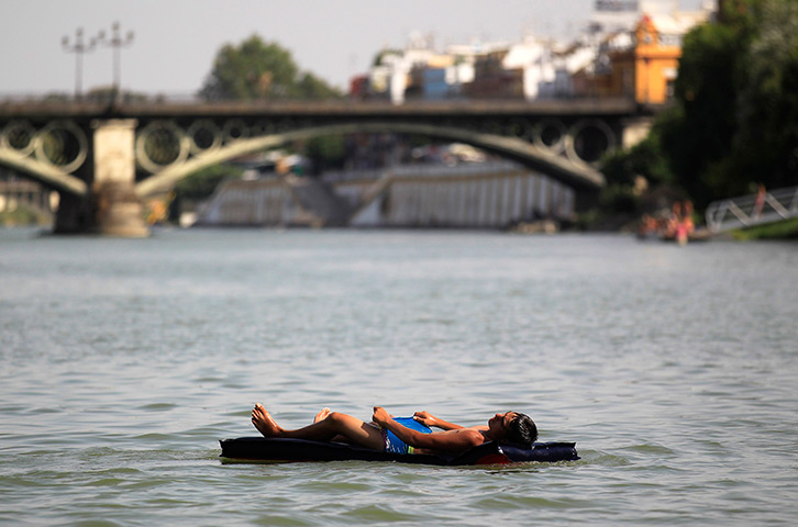 24 hours in pictures: A man rest on a floating mattress at the Guadalquivir river, Spain