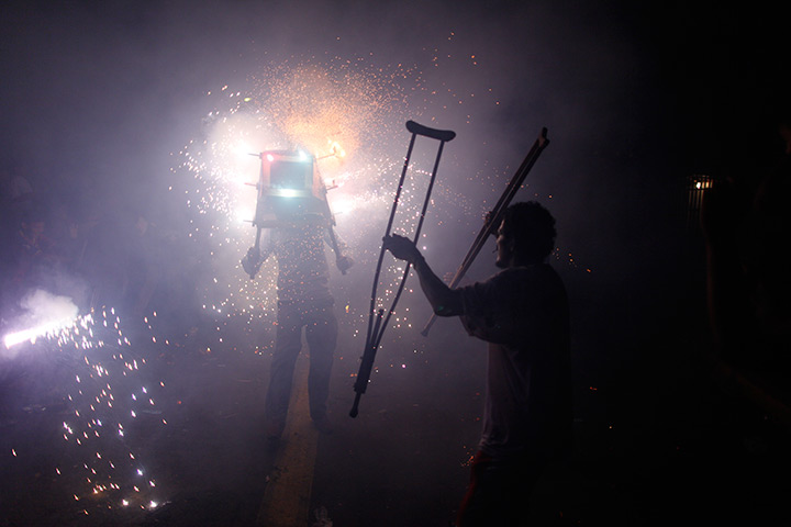 24 hours in pictures: A man lifts his crutches as he watches a fireworks, Santo Domingo
