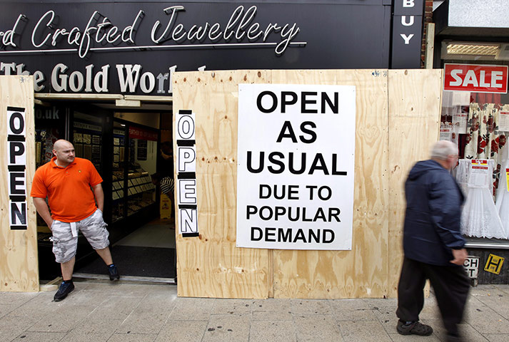 London riots aftermath: A Jewellery shop employee stands outside the shop