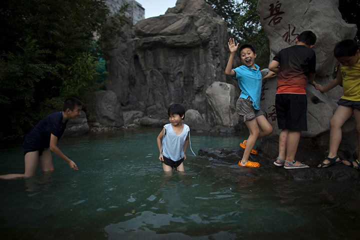 24 hours in pictures: Children play in a water pool on a summer day in Beijing, China