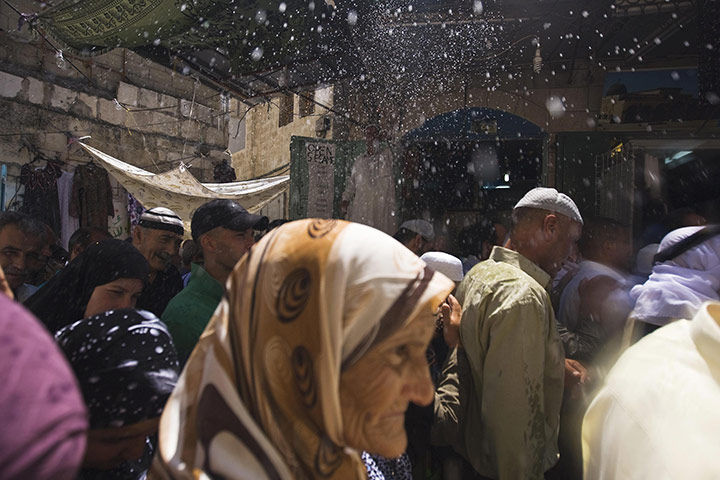 24 Hours: A Palestinian vendor sprays water on Muslim worshippers