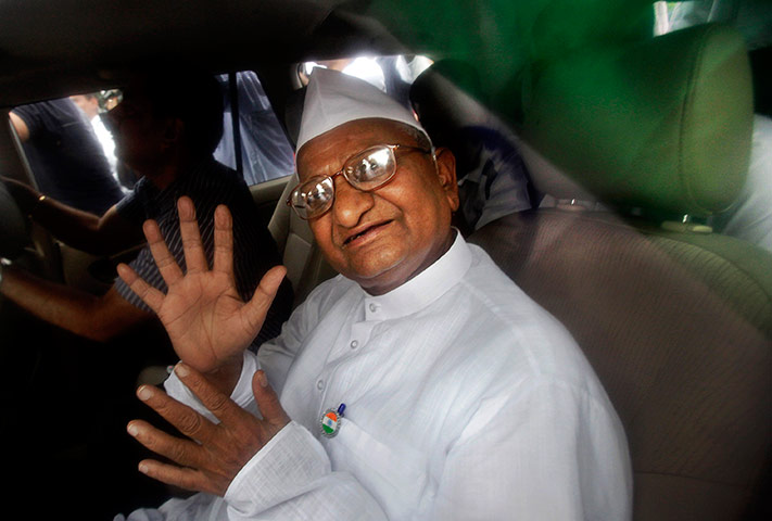Anna Hazare : Anna Hazare waves to supporters from the back of a police van