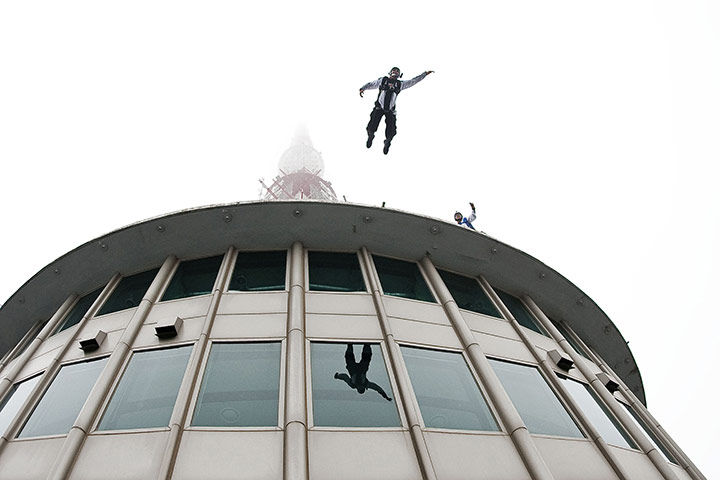24 hours in pictures: Seoul, south Korea: Member of Red Bull Air Force leaps off the Seoul Tower