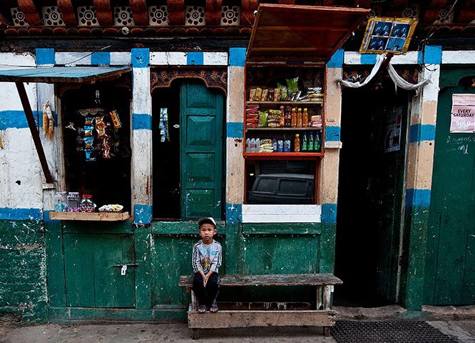 24 hours in pictures: Thimphu, Bhutan: A Bhutanese child sits outside a roadside shop 