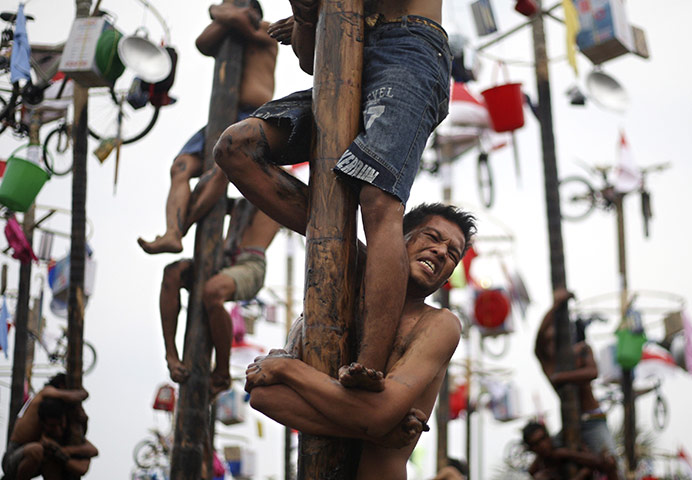 24 hours in pictures: Jakarta, Indonesia: Men participate in a greased pole climbing competition