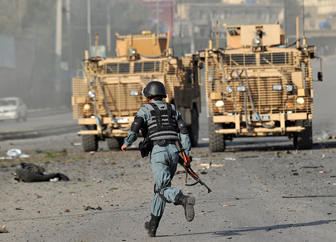Blast in Kabul: An Afghan security official runs past British armoured vehicles