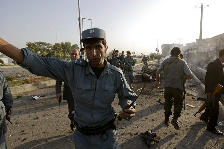 Blast in Kabul: A policeman gestures at the site of the suicide attack