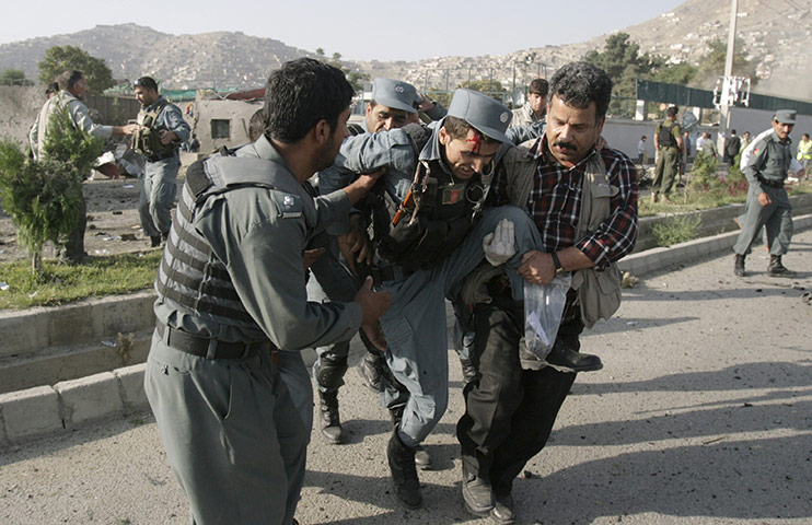 Kabul Attack: Afghan security forces carry a wounded policeman away from the site