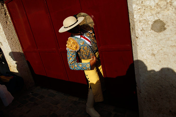 24 hours in pictures: A Spanish picador walks through a door before the start of a bullfigh