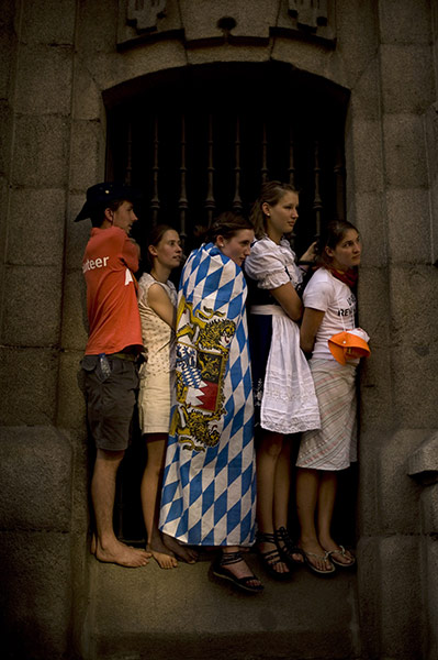 24 hours in pictures: Pilgrims stand on a windowsill as they wait for Pope Benedict, Madrid