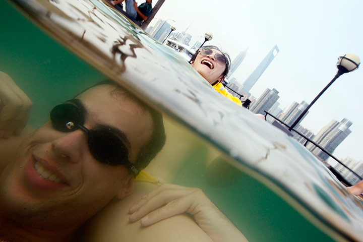 24 hours in pictures: A couple cool down in the hot weather at a swimming pool, China