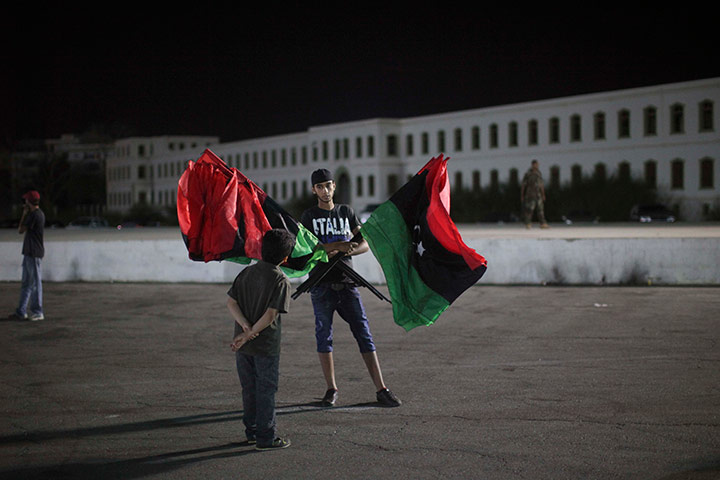 24 hours in pictures: A boy talks to a man selling flags, Libya