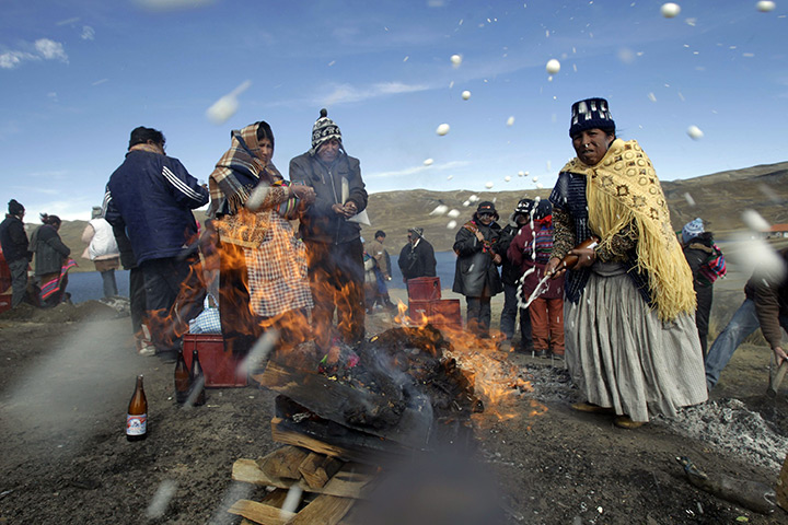 24 hours in pictures: An Aymara woman makes a beer offering to Pachamama